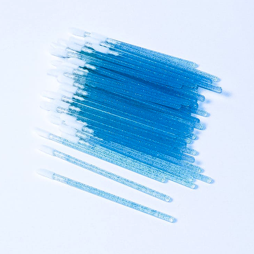 Pack of small pink lash brushes for eyelash extensions on white background